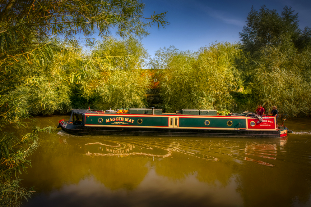 Narrowboat heading upriver passing the drainage channel that is the last vestige of the Roman Severn