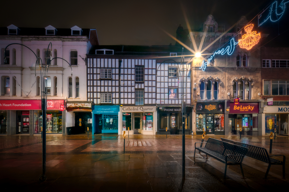 20th-century faux timber framing above the 19th-century shop fronts of Nos. 19a–23 obscures the 15th-century No. 19, the Fleece Inn, behind.